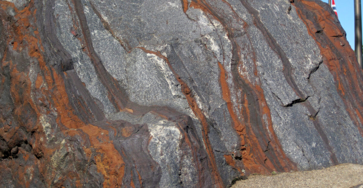 Banded iron formation BIF from the Precambrian of the Mesabi Iron Range in Minnesota USA Banded iron formations or BIFs are unusual dense marine sedimentary rocks consisting of alternating layers of iron-rich oxides and iron-rich silicates Most BIFs are Proterozoic in age although some are Late Archean They do not form in today s oceans - they re an example of an extinct rock type Many specific varieties of iron formation are known The most attractive type is jaspilite which is a reddish silvery gray banded rock consisting of hematite red chert jasper and specular hematite or magnetite Most BIFs have been subjected to one or more orogenic mountain-building events resulting in folding and or metamorphism BIFs are known from around the world but some of the most famous extensive deposits are found in the vicinity of North America s Lake Superior Basin Many BIFs have economic concentrations of iron and are mined as iron ores Stratigraphy Biwabik Iron-Formation Paleoproterozoic 1 878 Ga Locality display piece at Minnesota Discovery Center Chisholm Minnesota USA