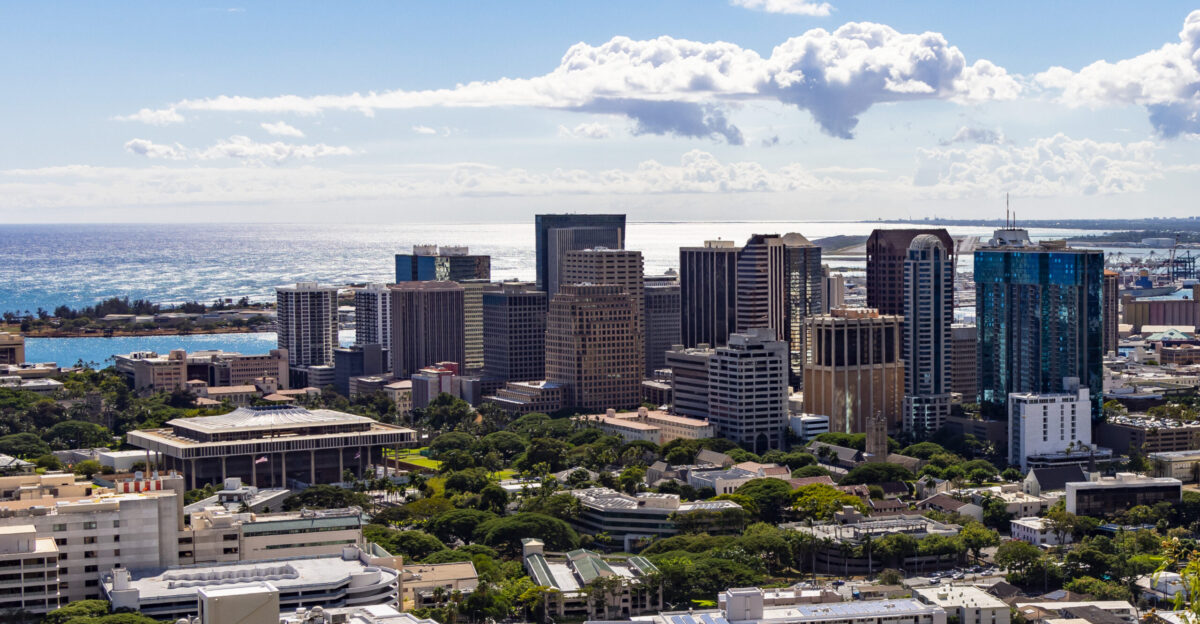 Picture of Downtown Honolulu taken at P owaina Punchbowl Crater National Memorial Cemetery of the Pacific showing Downtown Honolulu and the Hawaii State Capitol with the Reef Runway Daniel K Inouye International Airport in the background
