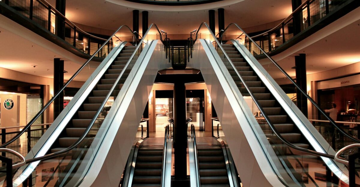 Symmetrical view of escalators in a modern shopping mall interior showcasing architecture and design