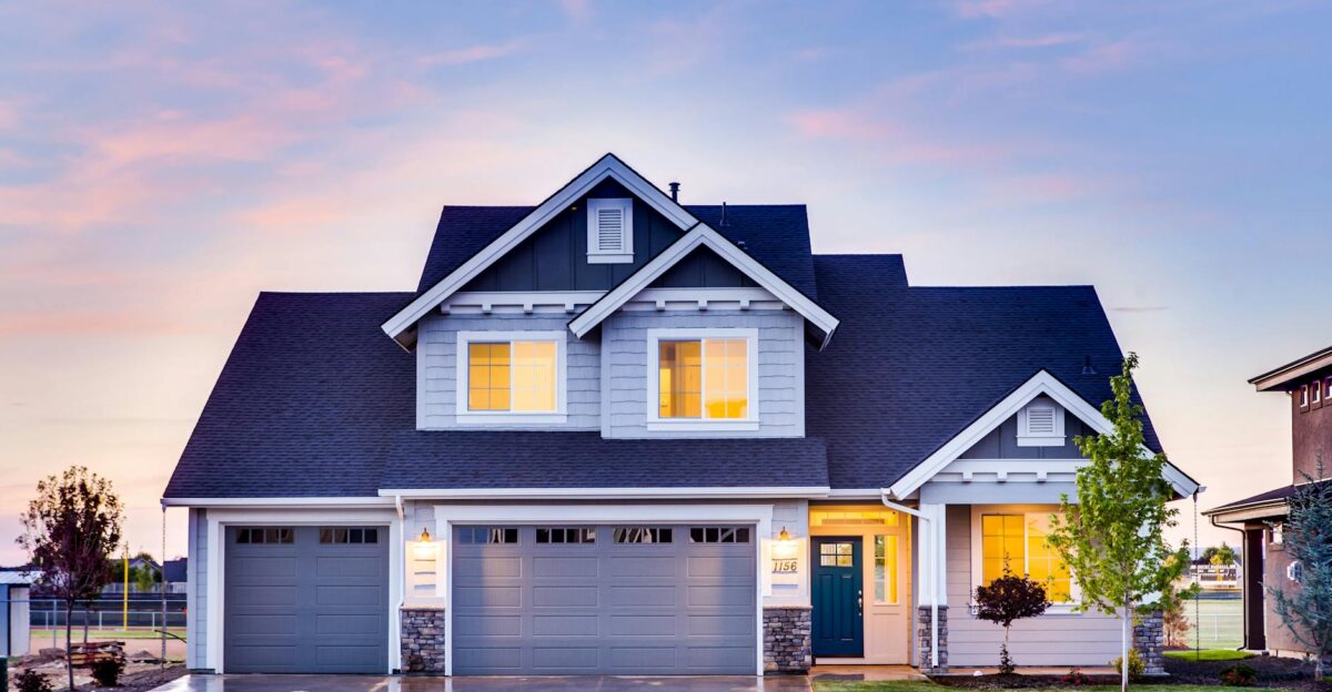 Beautiful two-story house with illuminated windows and garage at dusk