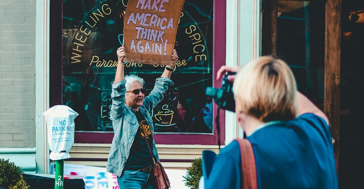 A woman holds a protest sign during a rally in Wheeling WV USA