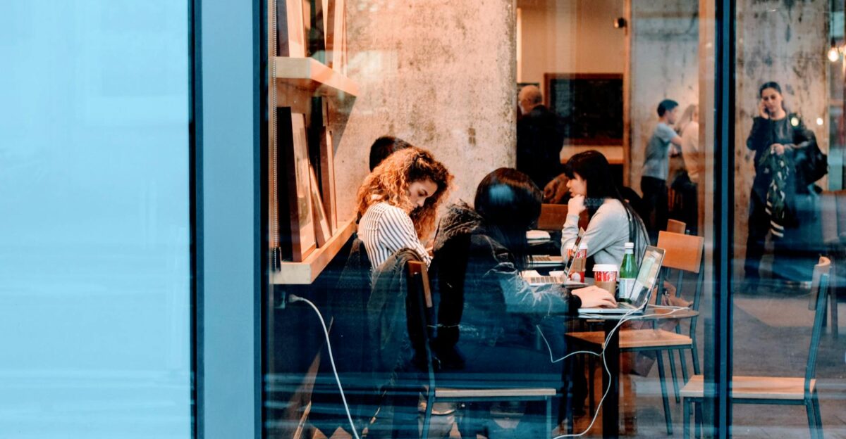 Group of adults working inside a stylish city cafe showcasing modern work culture