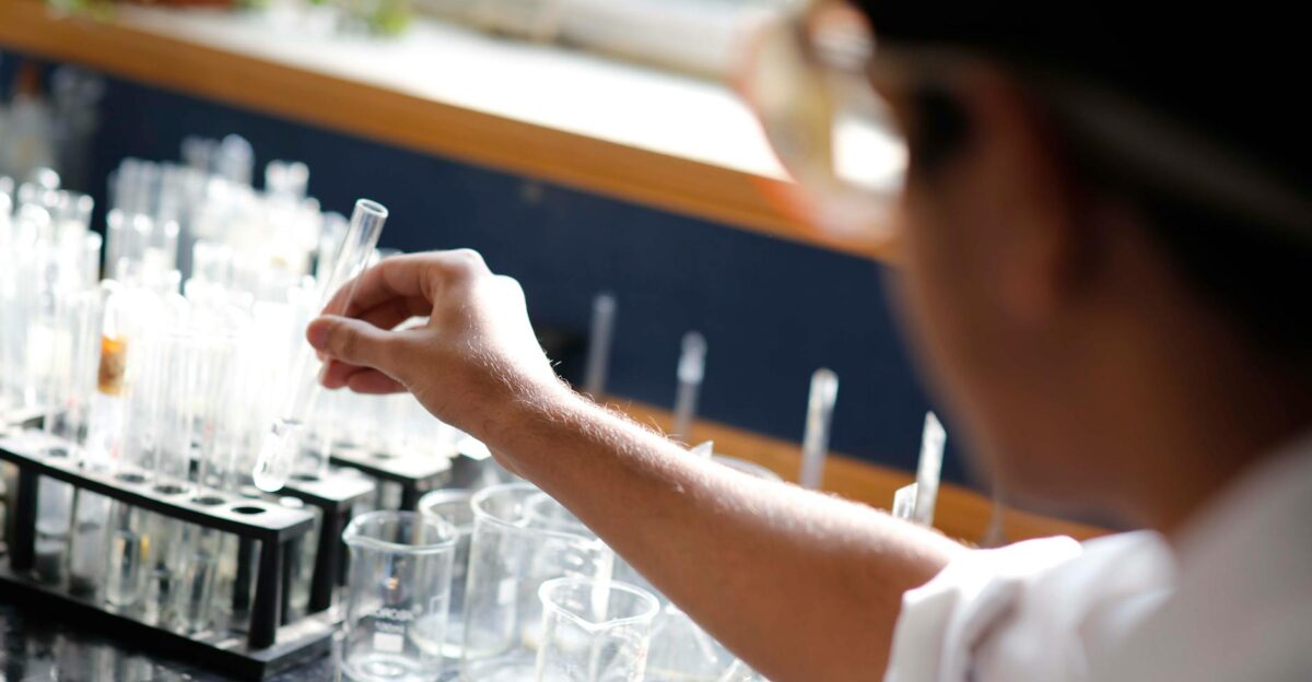 Student in chemistry lab picking test tube