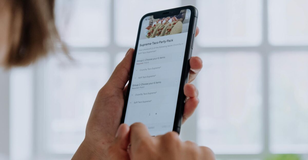 Close-up of hands using a smartphone to order food online through an app showcasing modern technology