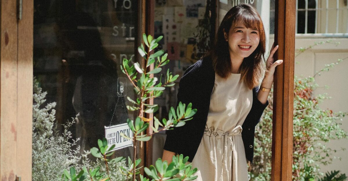 Smiling woman in caf doorway adding warmth and hospitality to a modern coffee shop