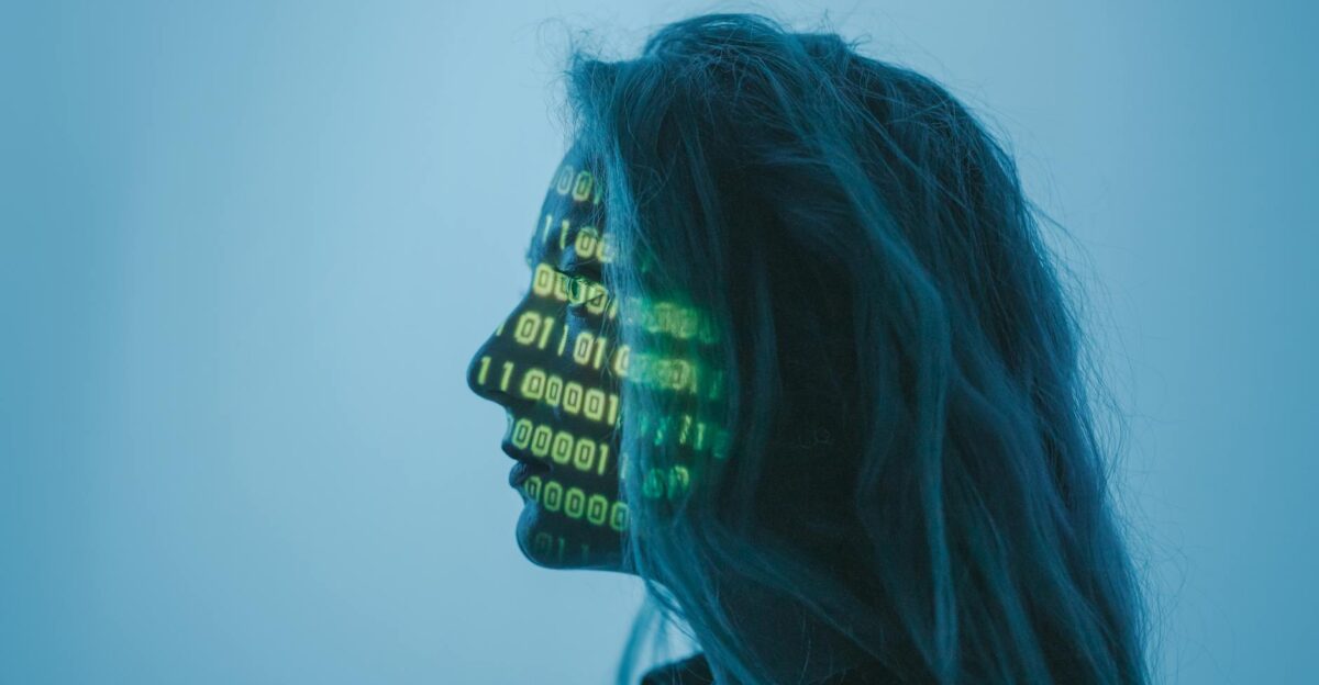 Silhouette of a woman with binary code projected on her face in a digital concept setting