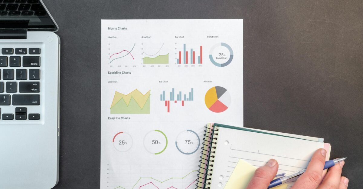 Overhead view of a business desk with charts and a laptop ideal for data analysis concepts
