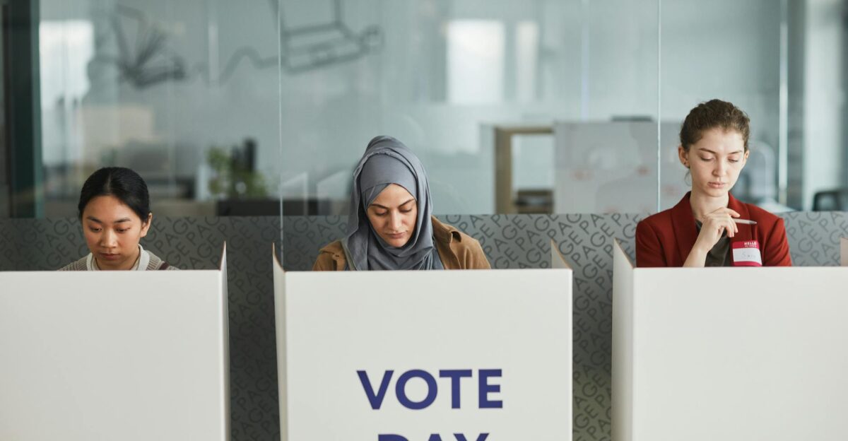 Three women voting in office cubicles Diverse representation focused and serious