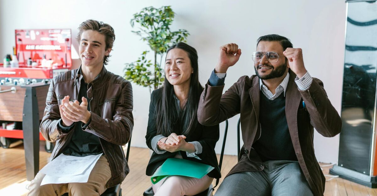 A group of diverse entrepreneurs in a workspace celebrating success and motivation