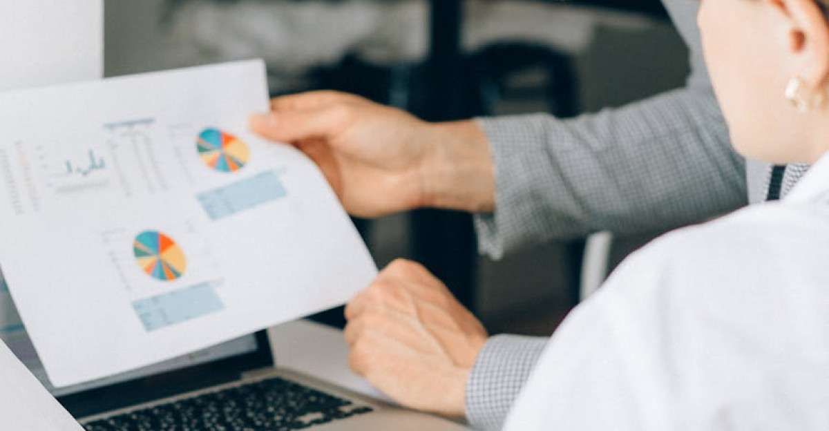 Two business professionals reviewing financial charts and graphs in a modern office setting