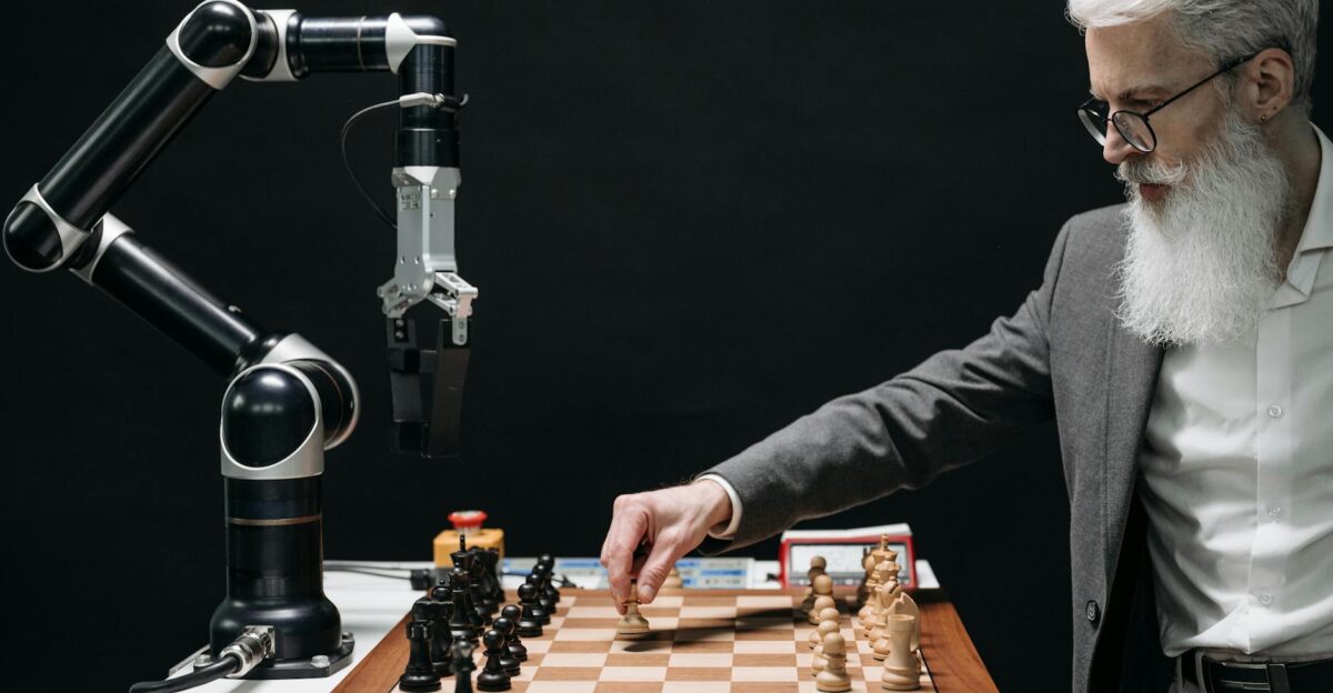 A bearded man strategically moves chess pieces while an AI robot arm assists in a futuristic game
