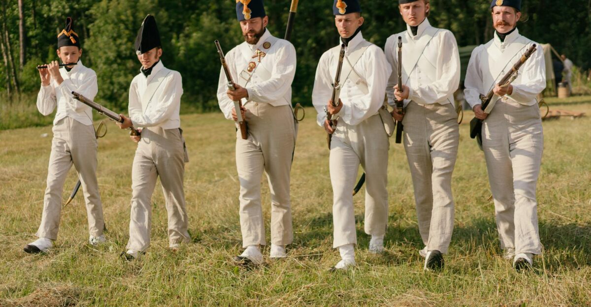 Group of historical reenactors marching in uniform with rifles on a sunny day