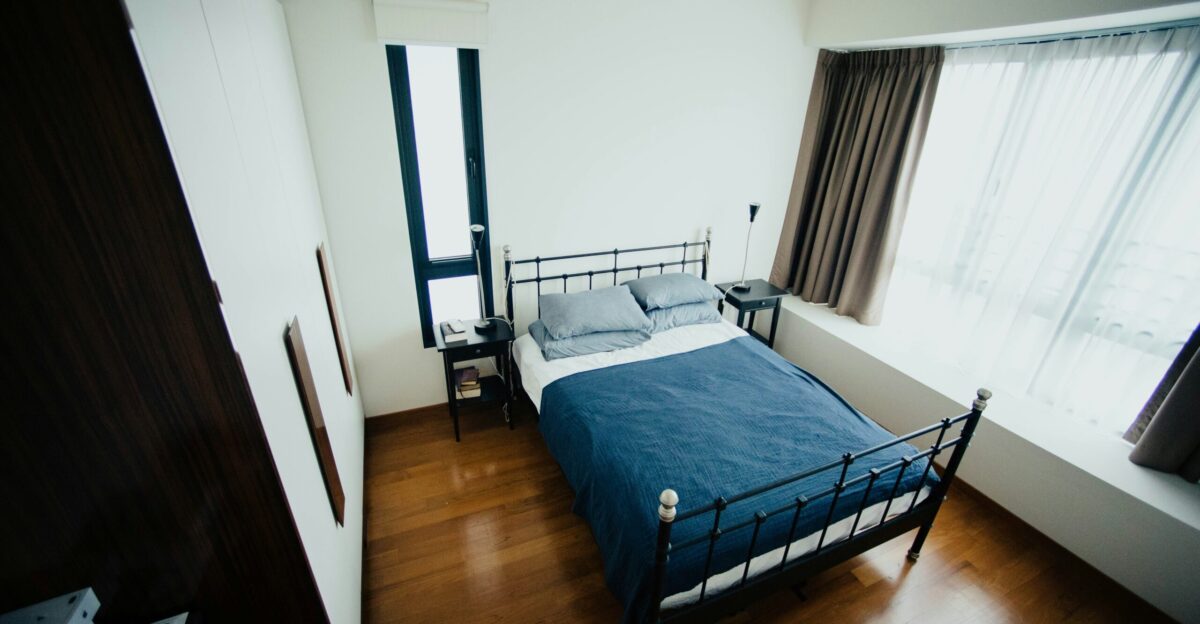 blue and white bed sheet and black bed frame in room
