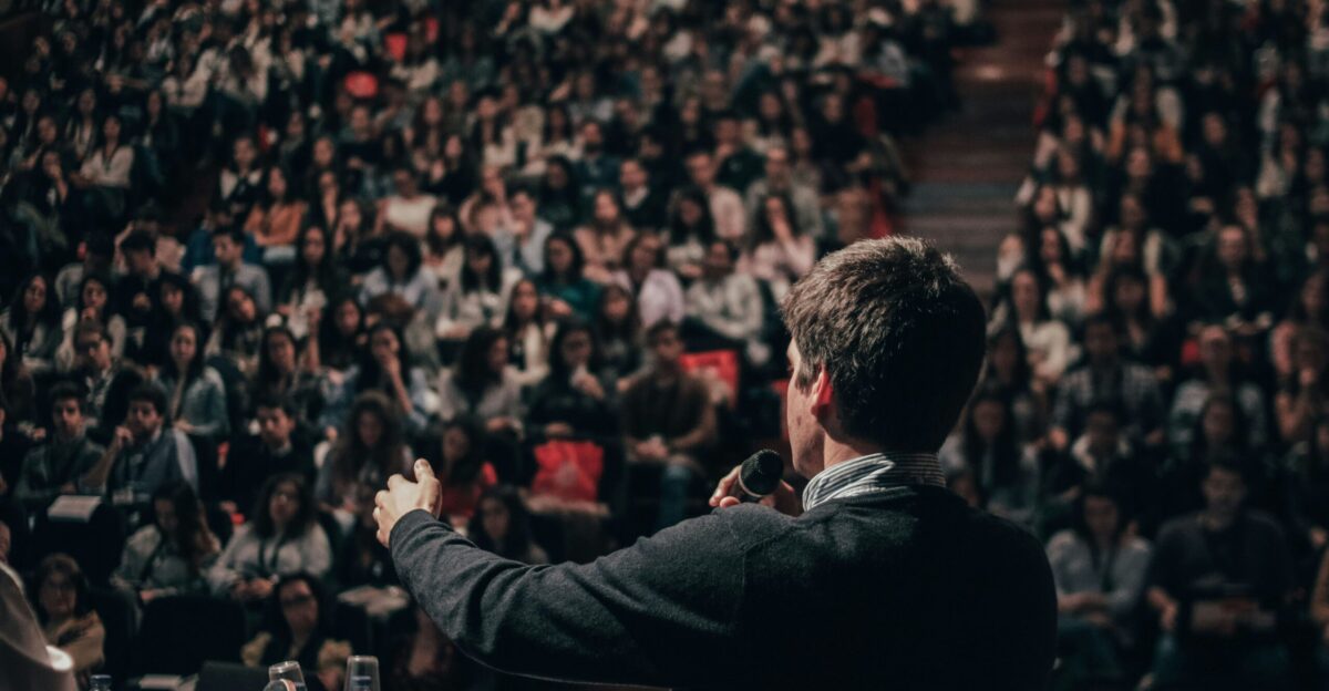 man speaking in front of crowd