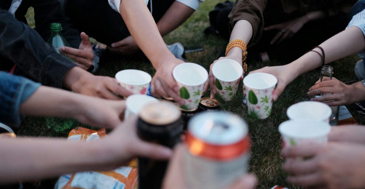 people holding white plastic cups