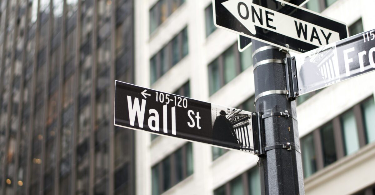 a pole with two street signs and a building in the background