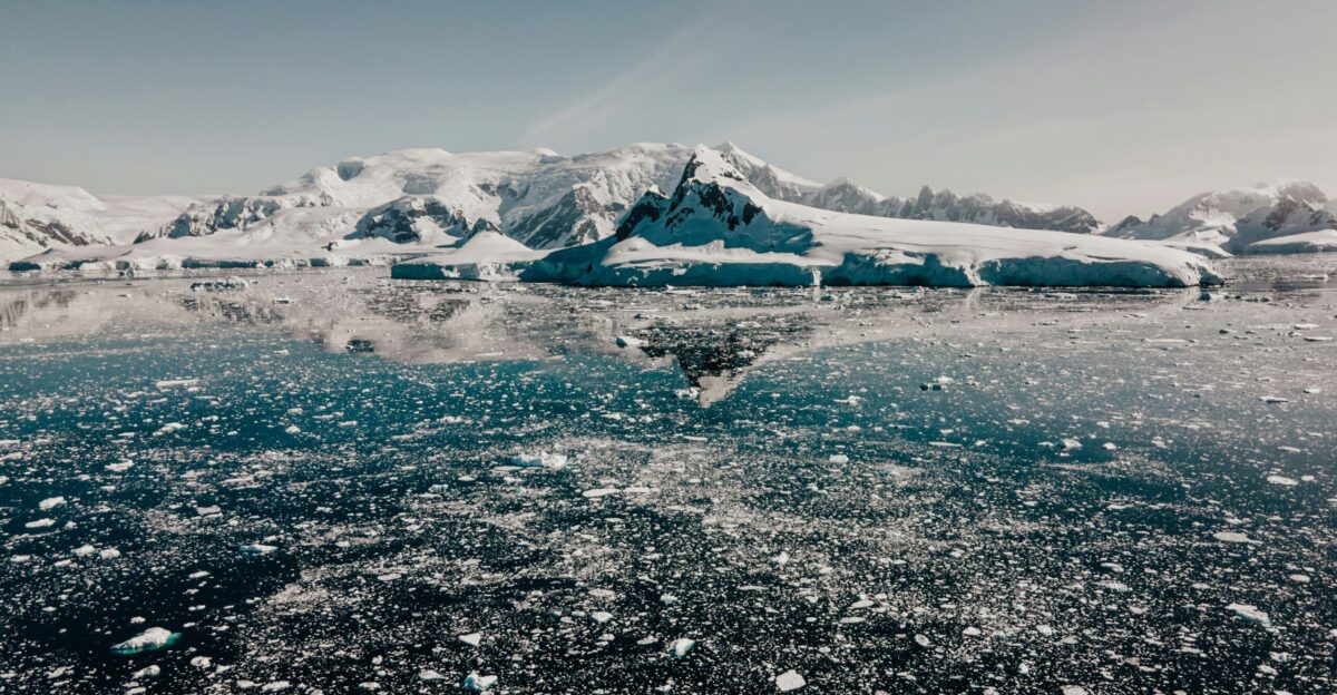 a large body of water surrounded by snow covered mountains