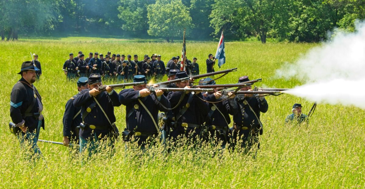 a group of men standing in a field next to each other