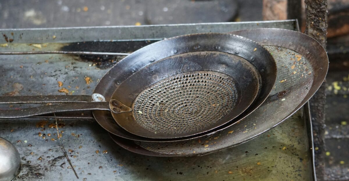 a metal strainer sitting on top of a metal tray
