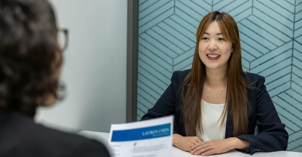 a woman sitting at a table with a piece of paper in front of her