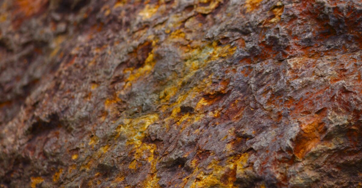 a close up of a rock with yellow and brown paint