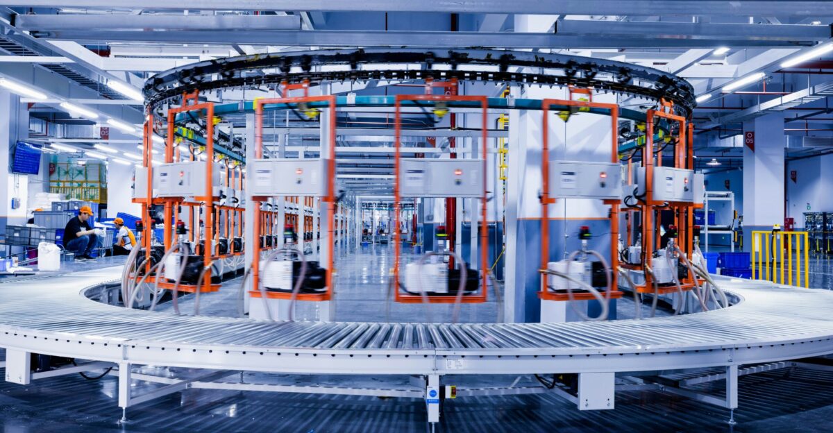 a large machine in a factory with people working on it