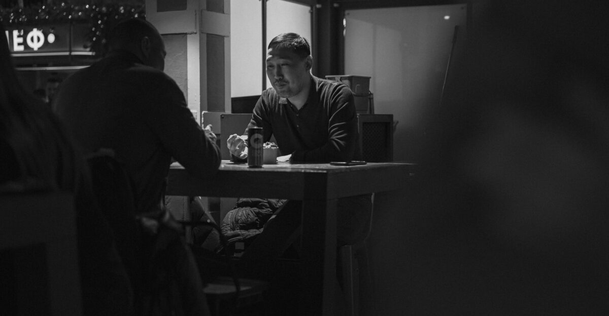 A black and white photo of a man sitting at a table