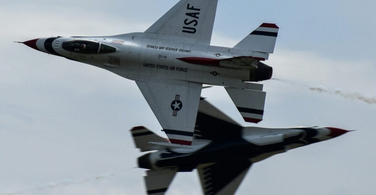 A fighter jet flying through a cloudy blue sky