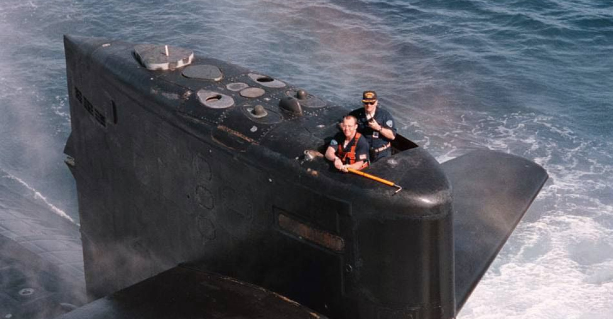 Crewman on board the U.S. Navys Los Angeles-class attack submarine USS Baltimore (SSN 704) stand by with a grappling hook to snag a mail shipment being lowered by an SH-60 "Seahawk" helicopter from Anti-Submarine Squadron Five (HS-5) July 17, 1996. The Baltimore is part of the aircraft carrier USS George Washington (CVN 73) Battle Group, which is just days away from completing their scheduled six-month deployment in the Mediterranean. by Howard Gorder