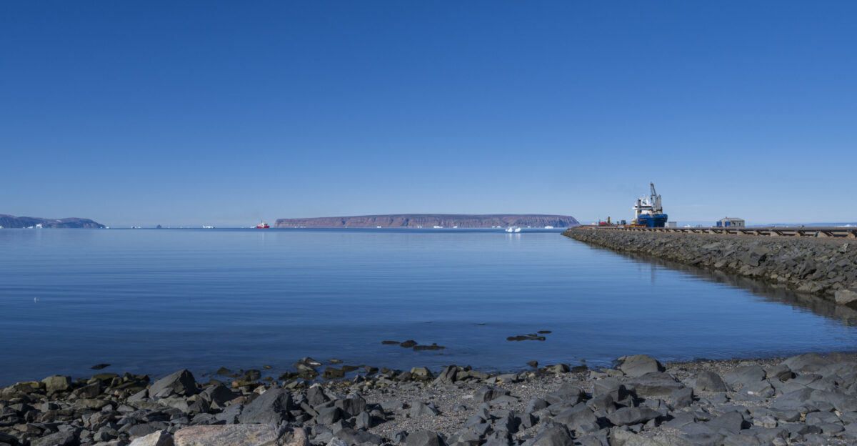 THULE AIR BASE Greenland - A Canadian Coast Guard ice breaker idles in North Star Bay while the cargo ship Ocean Gladiator prepares to depart Thule Air Base Greenland after delivering vital supplies as part of Operation Pacer Goose Aug 8 2022 Thule AB is home to the northernmost deep-water port in the world which is iced-in nine months of the year The base depends on supplies delivered during the annual operation to survive the long harsh winter season U S Space Force photo by Paul Honnick