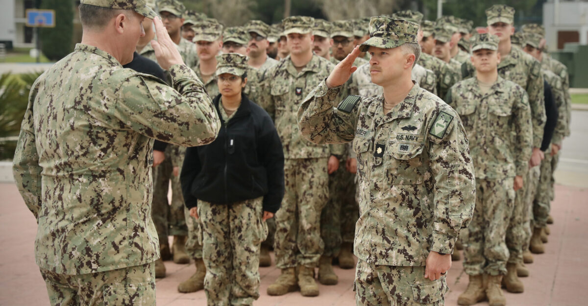 Lt Cmdr Josh Sasser right Naval Mobile Construction Battalion NMCB 1 operations officer salutes Cmdr James Stewart NMCB1 commanding officer during their deployment completion ceremony to mark NMCB1 s successful execution of critical construction and operational support throughout Europe and Africa aboard Camp Mitchell March 12 2025 22NCR commands naval construction forces for Navy Expeditionary Forces Europe-Africa Task Force 68 across the 6th Fleet area of operations to defend U S allied and partner interests