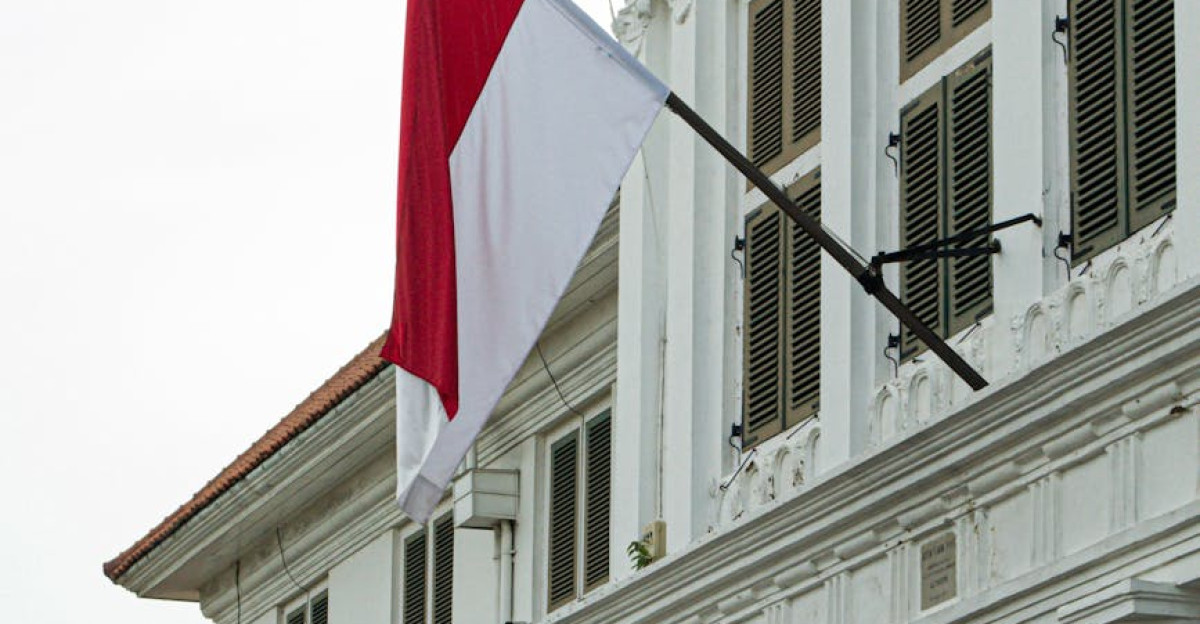 Vertical shot of a historic building with the Indonesian flag in Jakarta Indonesia