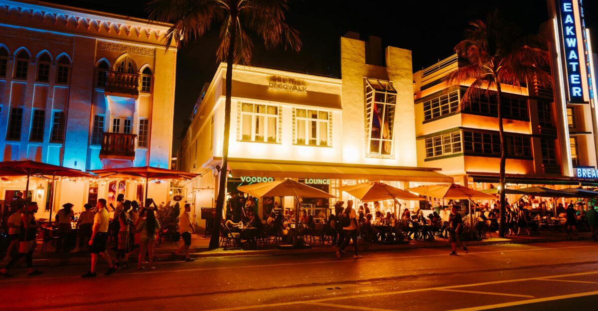 Crowds enjoying Art Deco nightlife on Ocean Drive under illuminated neon lights Miami Beach