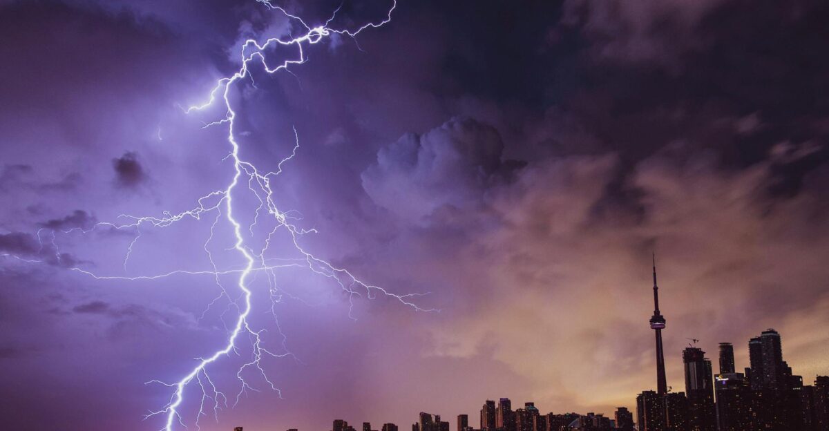 A striking lightning bolt illuminates the Toronto skyline against a dramatic stormy sky