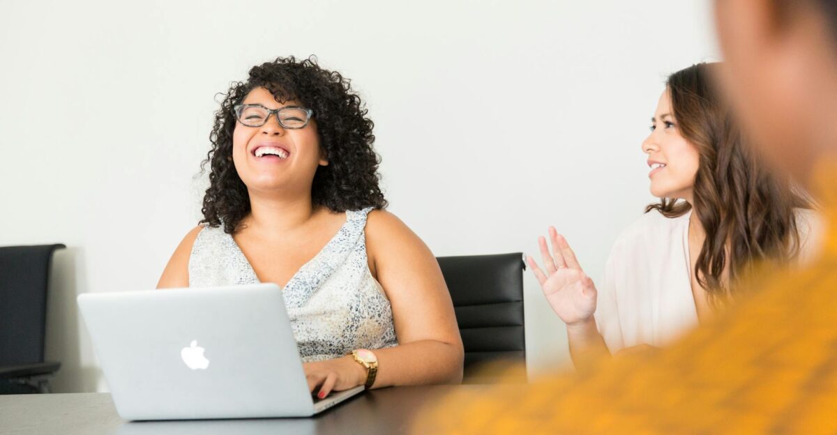Professional women engaged in a lively meeting at the office using technology