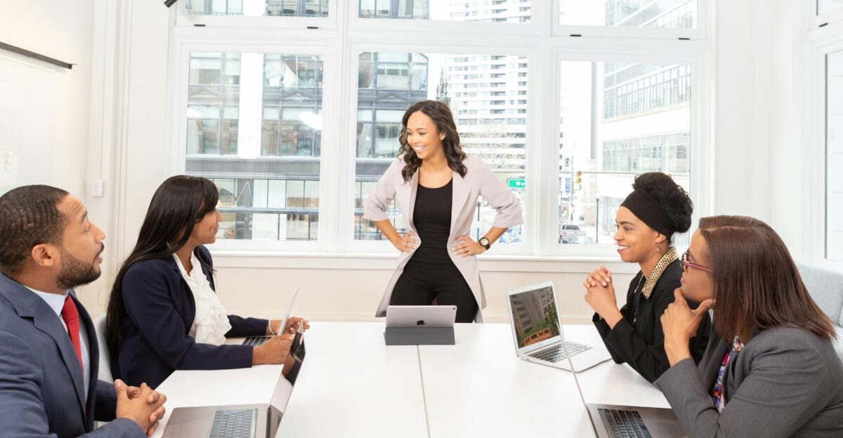 Diverse team engaged in a business meeting with laptops in a modern office setting