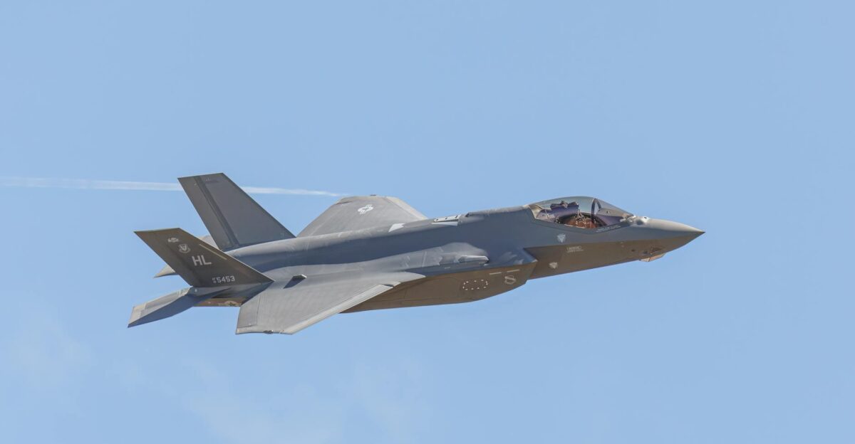 A sleek F-35 fighter jet soaring through a clear blue sky in flight
