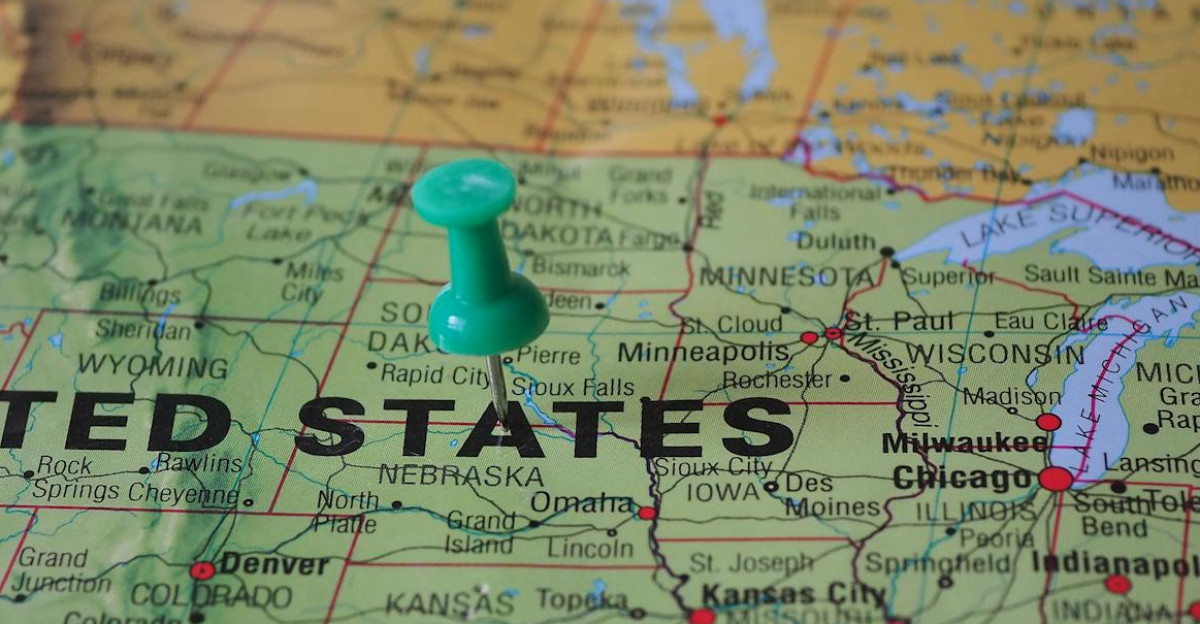 High-angle view of a map featuring the United States with a green pin indicating a specific location