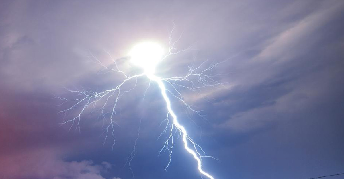 Lightning strikes through a fire-lit sky over Wenatchee WA creating a dramatic natural landscape