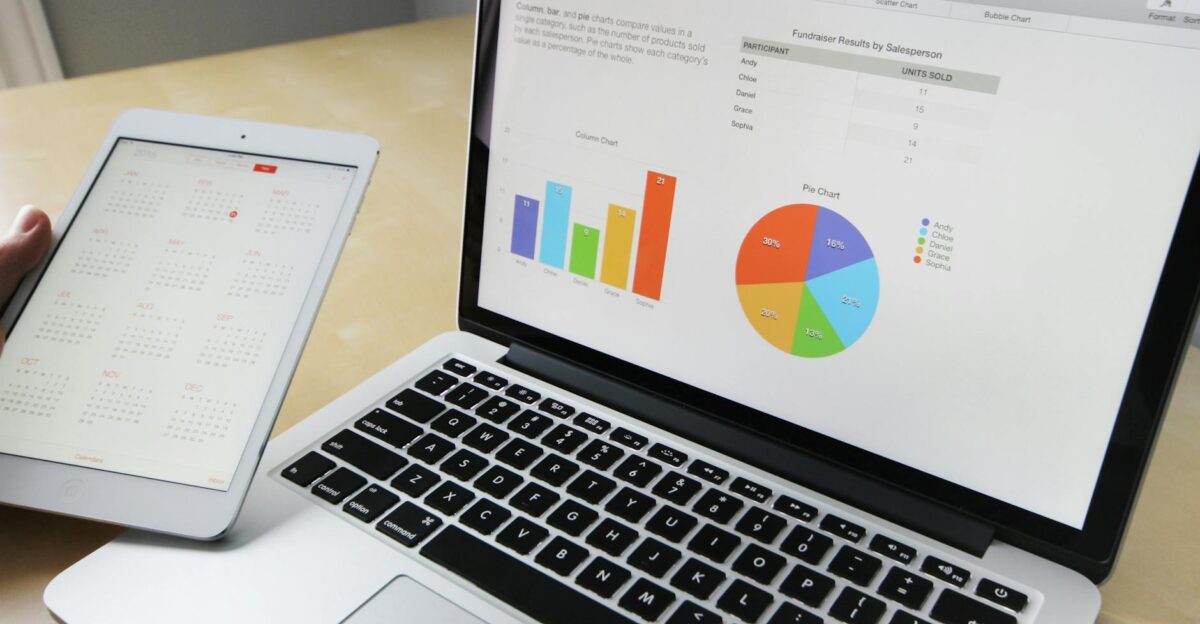 Laptop displaying charts and graphs with tablet calendar for data analysis and planning