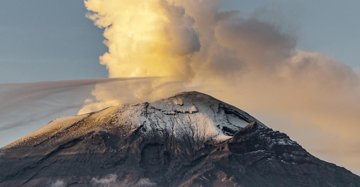 A stunning view of a volcano erupting at sunset surrounded by lush forests and a fiery sky