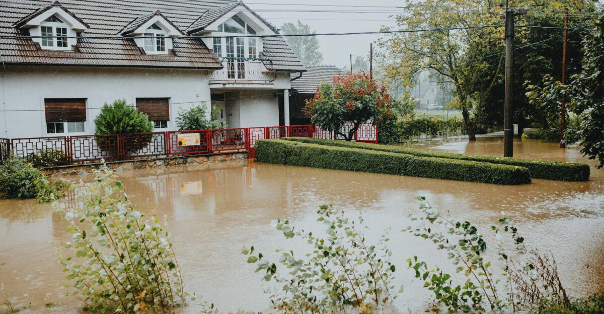 A suburban house surrounded by floodwaters after heavy rain showing impact of natural disaster