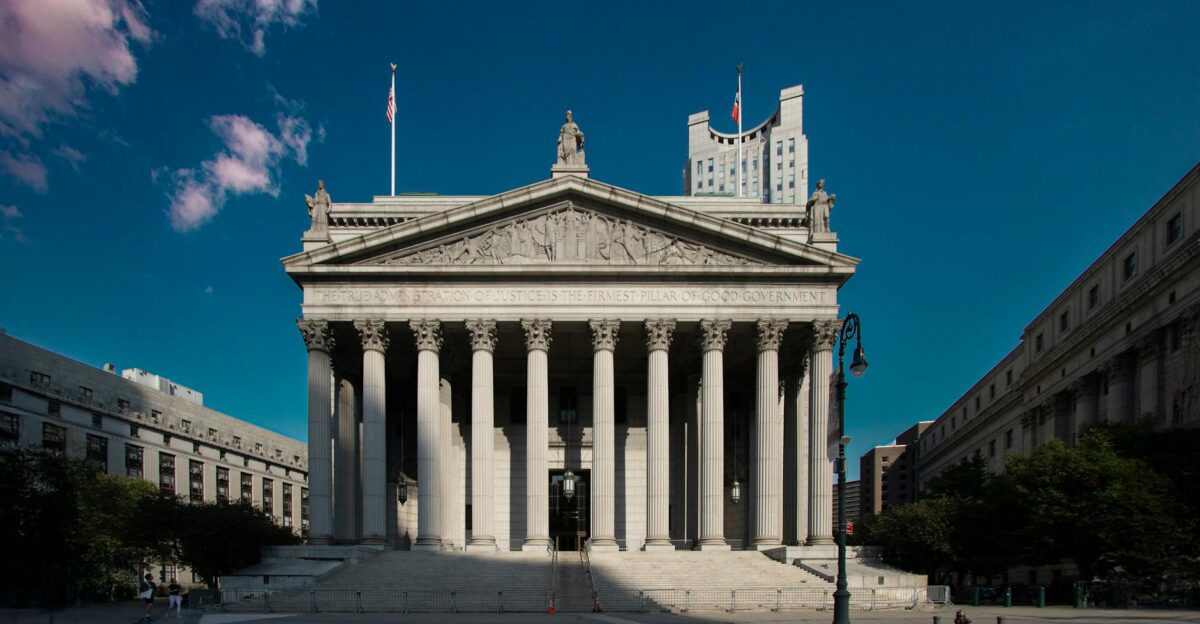 Front view of the Supreme Court building in New York City with blue skies