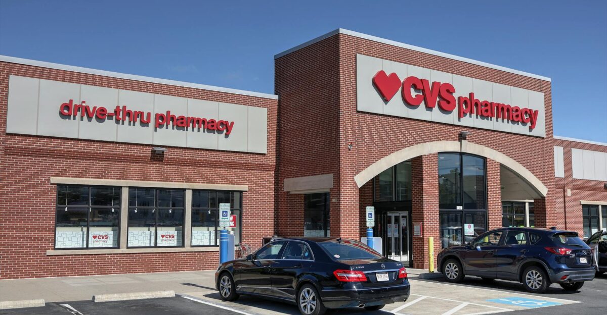 Brick CVS Pharmacy building with drive-thru cars parked outside