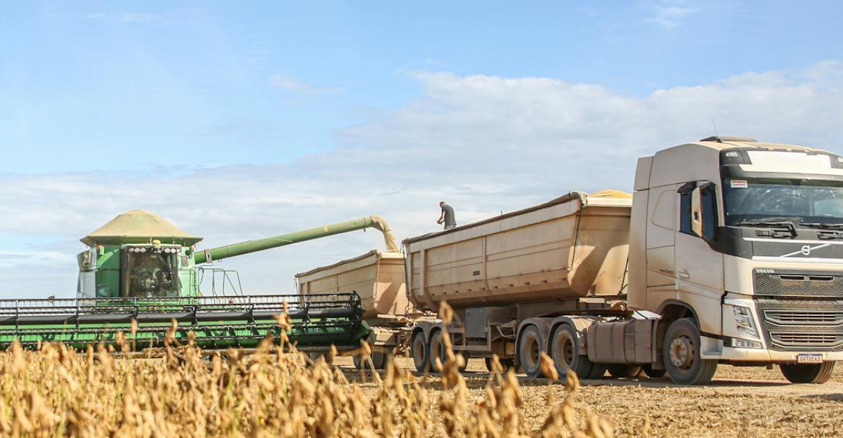 A combine harvester transfers soybeans to a truck during harvest on a sunny day in Paragominas Brazil