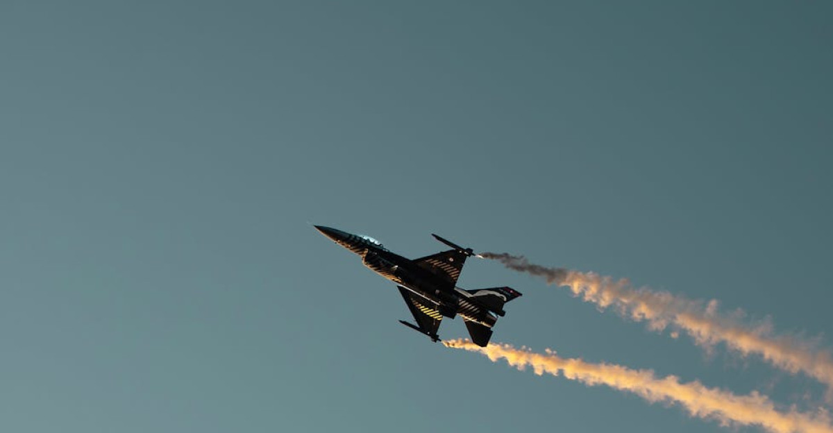 A fighter jet performs a stunning aerobatic maneuver against a clear sky