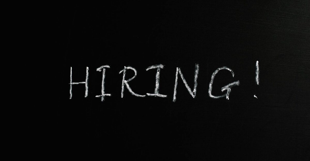 Close-up of the word Hiring written in white chalk on a blackboard ideal for recruitment themes
