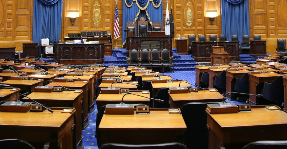 A beautiful view of the Massachusetts State House chamber with elegant decor and empty seating