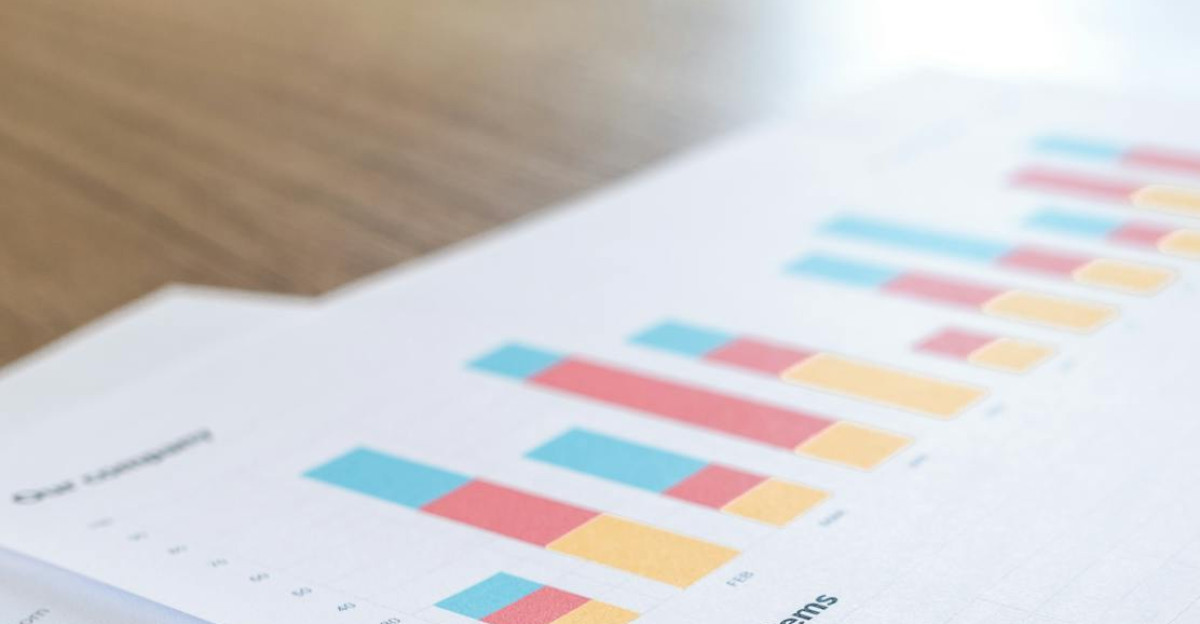 A close-up view of a business document with charts and graphs on a wooden desk
