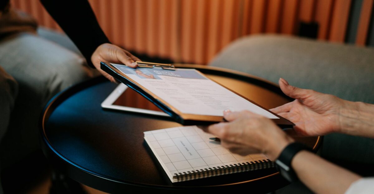Business professionals exchanging resume during meeting focusing on career advancement